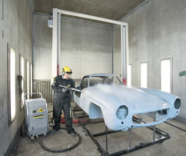 Ice Blast Works technician dry ice blasting a vintage convertible car body in a paint booth