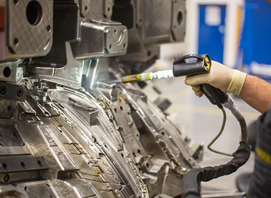Close-up of a technician dry ice blasting an automotive metal frame